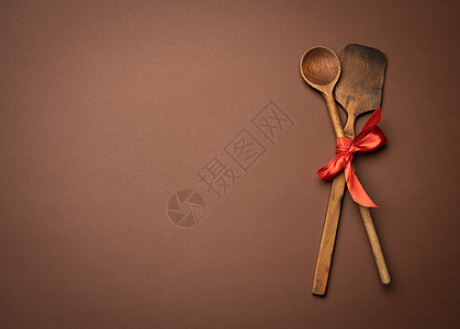 旧勺子和肥皂 用红丝带绑在棕色背景上图片