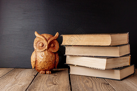 学校黑板背景下以乡村风格堆放在木桌上的书籍 书本上的猫头鹰是智慧和知识的源泉 概念欢迎回到学校 复制空间课堂记事本笔记本老师图书图片