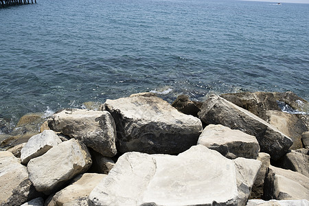 在晴朗的晴天 石头海滩的特写镜头 海滩上的岩石和鹅卵石被海浪和海浪淹没海洋旅游海景泡沫悬崖石头假期天线旅行蓝色图片