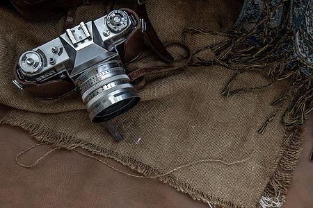 麻袋布背景上的老式相机的顶部视图图片