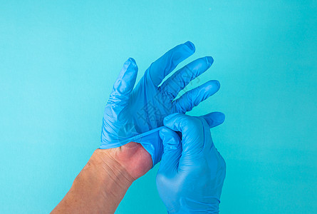 在蓝色背景上用手去掉手套预防护士手术科学药品医院橡皮诊所安全卫生图片