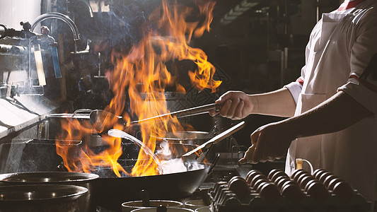 厨师在厨房忙着做饭餐具调子运动平底锅烧伤机器蔬菜油炸食物火炉图片
