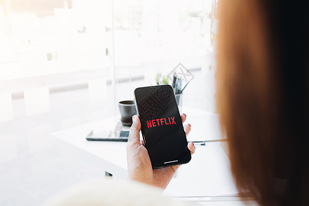 2020年12月 女性手持智能电话 在苹果iPhone Xs上印有Netflix标志 Netflix是全球流动电影和电视系列的提图片