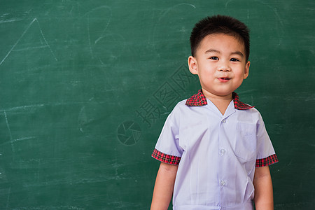 幼儿园儿童穿着学生制服在绿色学校黑板上微笑的校服背包男生木板学习课堂乐趣男性童年孩子孩子们图片