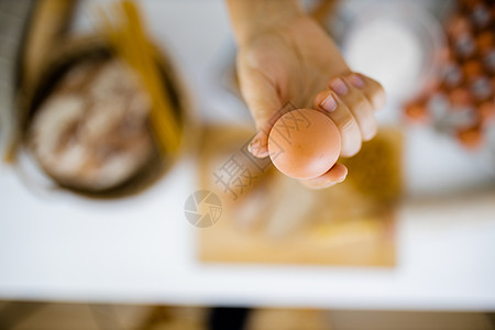手持鸡蛋高于表上成分的雌性手螺丝营养面条容器木辊手套女性面包砧板厨房图片