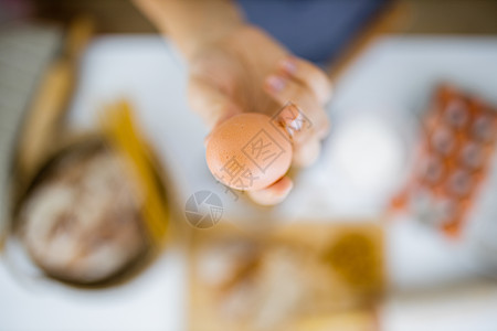 手持鸡蛋高于表上成分的雌性手饮食木辊砧板小麦面粉桌子午餐女性美食手套图片