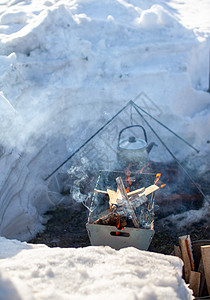 火上挂着一个煮饭的锅远足篝火摄影平底锅橙子木头荒野野餐活动烹饪图片