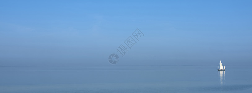蓝色天空下广大空湖的蓝水上孤单帆船运输海滩闲暇地平线假期旅游海洋孤独海岸支撑图片