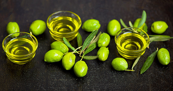 黑色背景的橄榄油和橄榄枝瓶子农业食物水果草本植物迷迭香桌子玻璃油壶植物图片