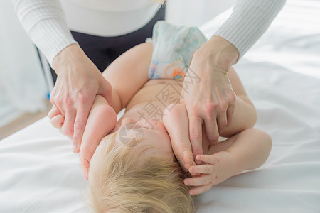妈妈为宝宝的腿做婴儿体操 近一点家庭乐趣母性童年孩子健身房肚子按摩卫生治疗图片
