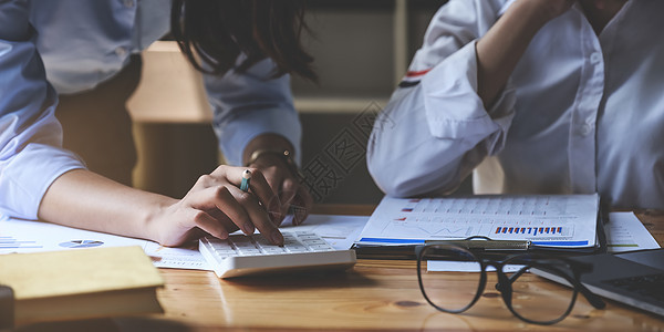 一群亚洲女商务人士会计师或银行家使用计算器和审计财务规划销售来实现目标图片