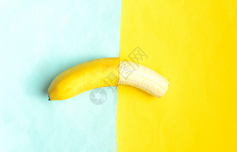 蓝黄背景的香蕉部分剥皮 热带夏季水果健康营养小吃食物甜点情调海滩异国蓝色义者图片