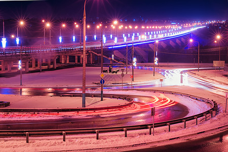 冬季晚上在桥上行驶的汽车头灯的痕迹 湿沥青中的灯光反射灯笼驾驶车辆景观运动街道交通市中心运输辉光图片