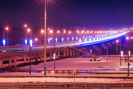 冬季晚上在桥上行驶的汽车头灯的痕迹 湿沥青中的灯光反射车辆运输大灯运动灯笼辉光街道夜景踪迹市中心图片