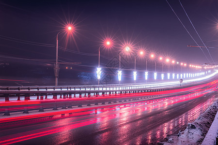 冬季晚上在桥上行驶的汽车头灯的痕迹 湿沥青中的灯光反射景观运输市中心夜景灯笼交通运动街道辉光车辆图片