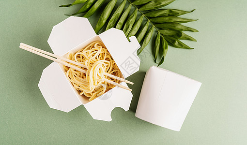 开开放的WOK纸箱 面条和筷子 在绿色背景上制成设计顶端视图公寓女士纸盒纸板嘲笑送货午餐包装空白小样盒子图片