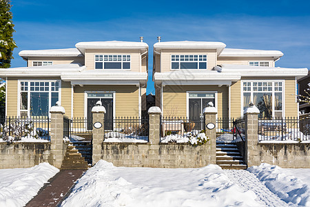 走开加拿大寒冬阳光明媚的天气下雪时 住家有前院的双人住宅背景