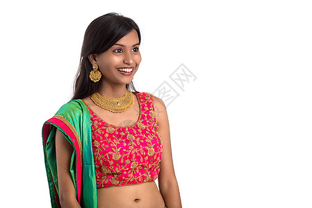 美丽的印度传统女孩摆着白色背景的姿势微笑婚礼文化女士衣服裙子珠宝女性新娘首饰图片