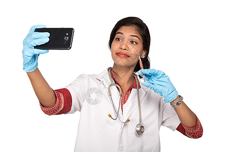 医生手机女医生使用听诊器自拍 用智能手机在白色背景上注射女士专家实习生护士药品女性微笑女孩电话诊所背景