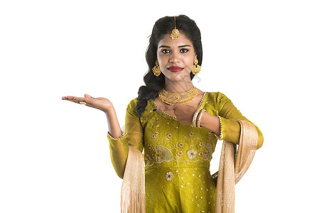 白色背景下 欢快的印度传统年轻女性在手掌上展示一些复制空间的肖像棕榈节日商业产品文化推介会女孩女士手势庆典图片