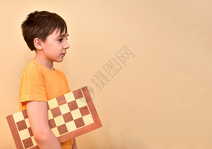 男孩手握着棋盘 梦想 思考游戏 空闲的文字空间是免费的童年小学生竞赛男性木板学生活动娱乐智力领带图片