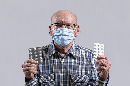 戴眼镜的秃头老人 手上拿着药丸的医用面具男人疾病处方男性眼镜老年病药片长老抗生素保健图片
