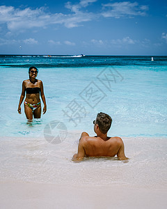 阿鲁巴加勒比棕榈海滩 在阿鲁巴有棕榈树的白长沙沙滩海景天蓝色异国棕榈生活列斯晴天海岸游客男人图片