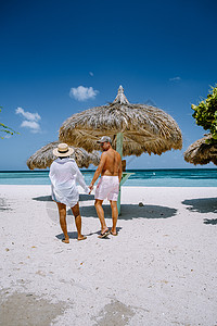 阿鲁巴加勒比棕榈海滩 在阿鲁巴有棕榈树的白长沙沙滩幸福旅游女士天蓝色手掌海景度假村棕榈海滩夫妻图片