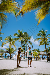 阿鲁巴加勒比棕榈海滩 在阿鲁巴有棕榈树的白长沙沙滩情调女性旅行棕榈海洋幸福游客天堂男人假期图片