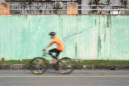 男人用模糊的动作在自行车上超速行驶图片