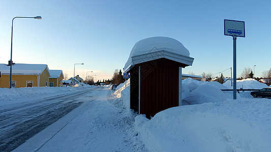 在瑞典北部一个小雪小镇的一个公共汽车站天空长椅交通旅游旅行冷冻汽车运输季节天气图片