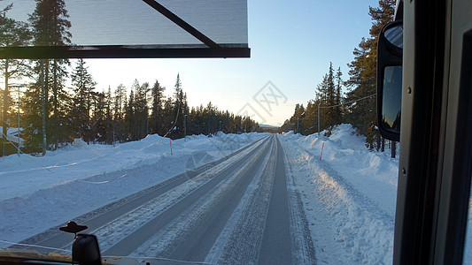 巴士日落时看到雪下的道路地标森林交通旅行车辆窗户国家街道驾驶汽车图片