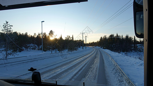 巴士日落时看到雪下的道路街道汽车交通地标驾驶运输车辆天气窗户城市图片