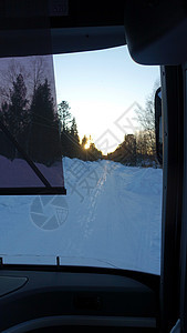 巴士日落时看到雪下的道路旅行国家森林天气假期汽车驾驶车辆山脉天空图片