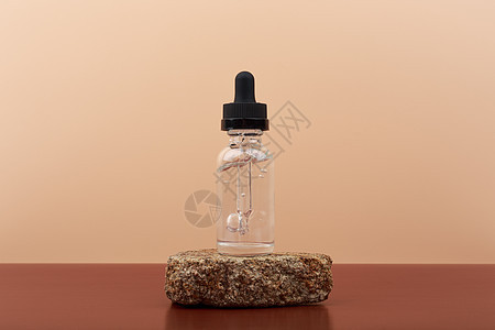 用透明瓶装的皮肤血清 放在石头上 对抗蜜蜂背景和复制空间图片