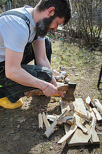 一个穿长裤的胡子人 砍柴烧火 伯奇树枝工具树桩燃料成人连衣裤行动材料工匠刀刃精神图片