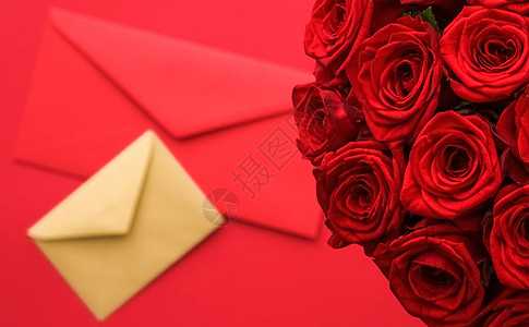 情人节的情书和送花服务 红色背景的豪华红玫瑰花团和纸信封红底邮政生日邀请函热情通讯奢华邮件平铺花朵玫瑰图片