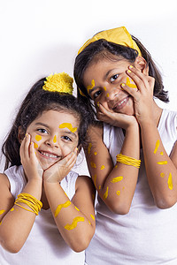 两个小女孩用她的脸彩绘来庆祝黄色 da女性艺术品画家艺术家孩子们娱乐绘画快乐化妆品派对图片