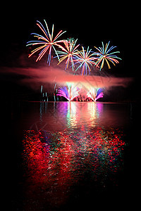 水面上美丽多彩的烟花 夜幕 节日和庆典的概念 笑声派对星星周年海滩展示烟火反射天空乐趣焰火图片