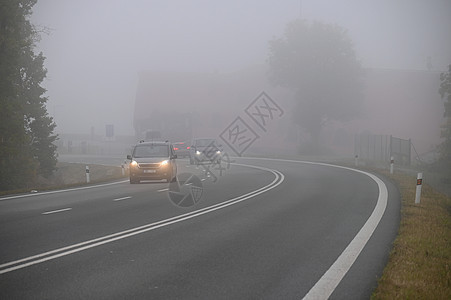 汽车在雾中的路上 秋季景观冬季危险的道路交通薄雾季节挡风玻璃下雨预报大灯运动沥青旅行运输图片
