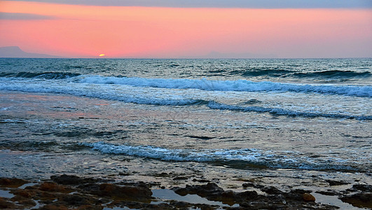 美丽的夏日海边日落 海滩上的迷人风景 波浪和太阳的反射 假期和假期旅行的背景 希腊克里特岛橙子海浪蓝色天空热带阳光天堂地平线全景图片