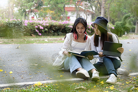 两名年轻漂亮的女大学生在户外学习 辅导他们在大学公园为即将到来的考试做准备图片