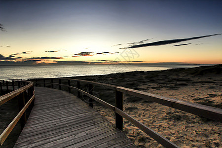 在西班牙阿利坎特的日出时 Wooden 步行走向海滩地平线金子支撑场景热带太阳人行道竞技场村庄海洋图片