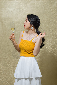 美丽的亚洲年轻女子 在金色背景上举酒杯 党的概念女性魅力周年奢华女士纪念日成功派对庆典酒精图片