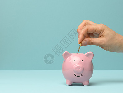 粉红猪猪银行和手扔硬币里面 金融储蓄概念图片