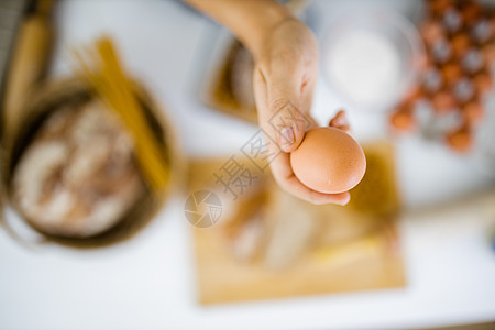 手持鸡蛋高于表上成分的雌性手木辊午餐美食容器塑料酵母手套碳水化合物砧板图片