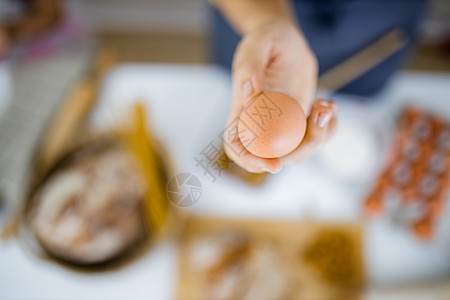 手持鸡蛋高于表上成分的雌性手塑料女性容器午餐手套烹饪砧板美食螺丝面条图片