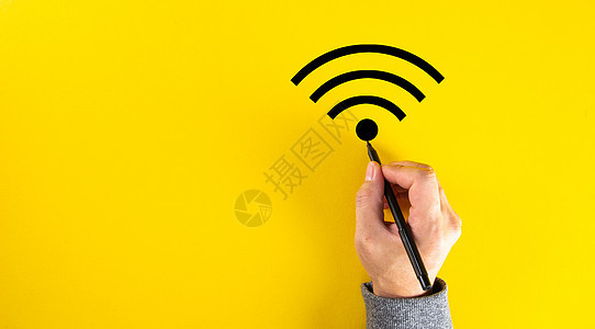 一只男性手在黄色背景上绘制 wifi 信号 带有复制空间图片