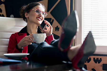 使用电话喝咖啡的女商界人士顾客自雇商业办公室咖啡生意人杯子套装顾问职业图片