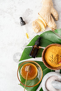 桌上的天然化妆品成分 肿瘤粉 蜂蜜 姜汁和有机树叶上的必要油热带叶子血清植物玻璃疗法产品药品健康瓶子图片